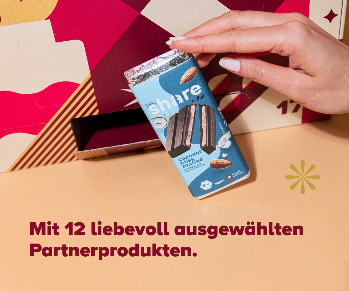 Hände halten Coconut Bliss Praline Schokolade von Share vor dem Adventskalender – eines der Partnerprodukte
